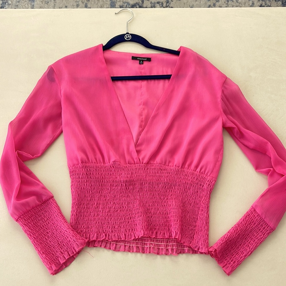 Long sleeve v-neck blouse with ruched band at sleeves and waist. Sheer sleeves